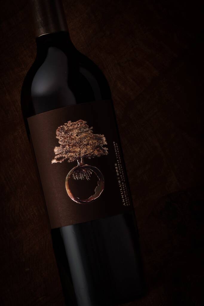 Dark image of bottle with bronze tree logo