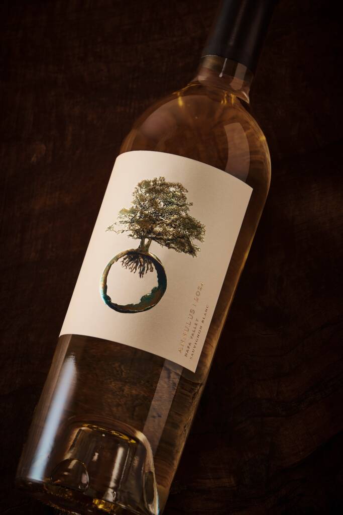 Sauv Blanc bottle lying at an angle with cream-colored label and tree icon