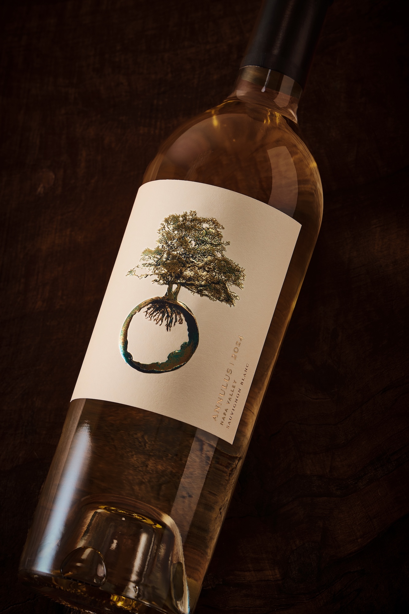 Sauv Blanc bottle lying at an angle with cream-colored label and tree icon