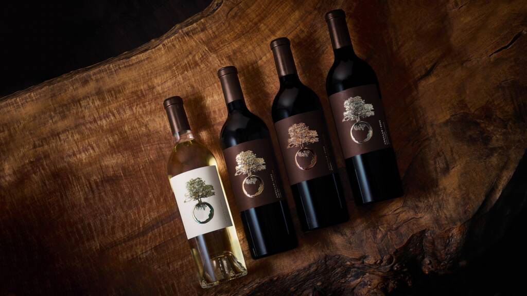 4 bottles at an angle on a wood-grained table